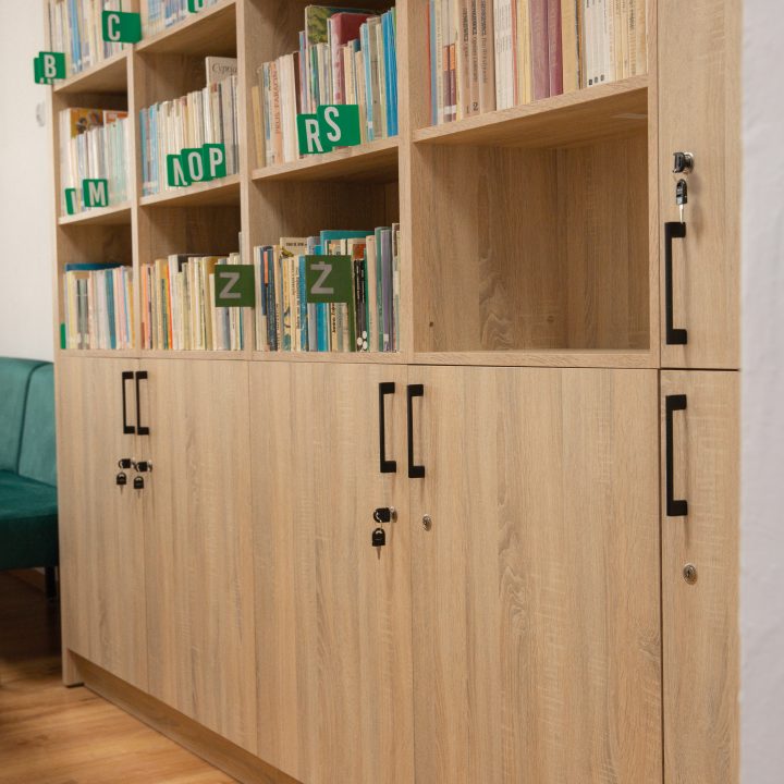 Realizacja MiD Business: meble na wymiar do szkoły w Dąbrowie. Biblioteka z regałami i siedziskami oraz gabinet dyrektora z szafą, biurkiem i komodą.
