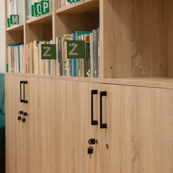 Realizacja MiD Business: meble na wymiar do szkoły w Dąbrowie. Biblioteka z regałami i siedziskami oraz gabinet dyrektora z szafą, biurkiem i komodą.
