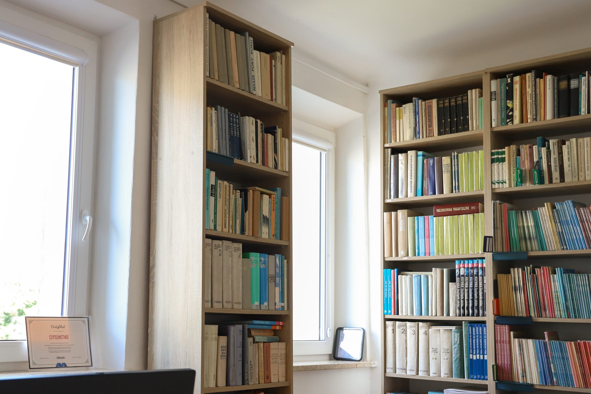 Realizacja MiD Business: meble na wymiar do szkoły w Dąbrowie. Biblioteka z regałami i siedziskami oraz gabinet dyrektora z szafą, biurkiem i komodą.