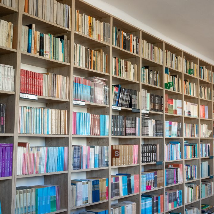 Realizacja MiD Business: meble na wymiar do szkoły w Dąbrowie. Biblioteka z regałami i siedziskami oraz gabinet dyrektora z szafą, biurkiem i komodą.