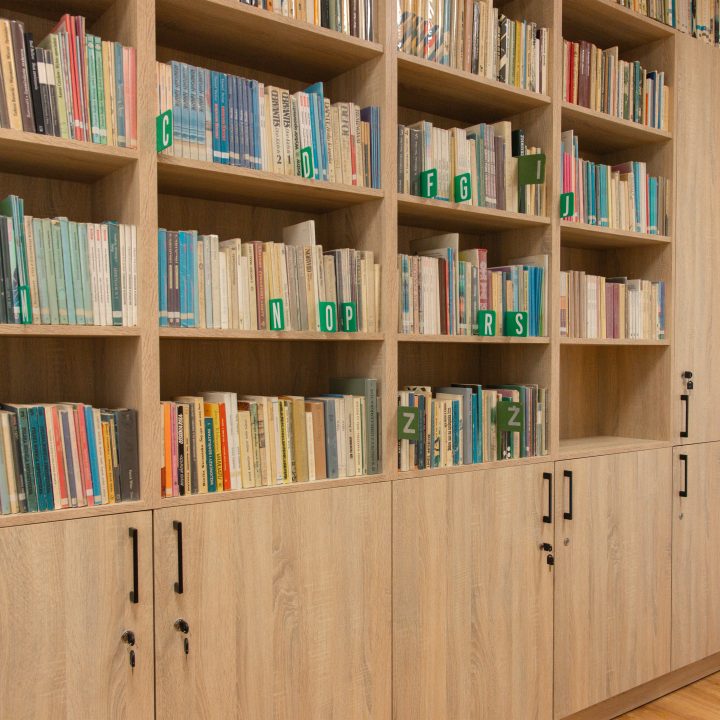 Realizacja MiD Business: meble na wymiar do szkoły w Dąbrowie. Biblioteka z regałami i siedziskami oraz gabinet dyrektora z szafą, biurkiem i komodą.