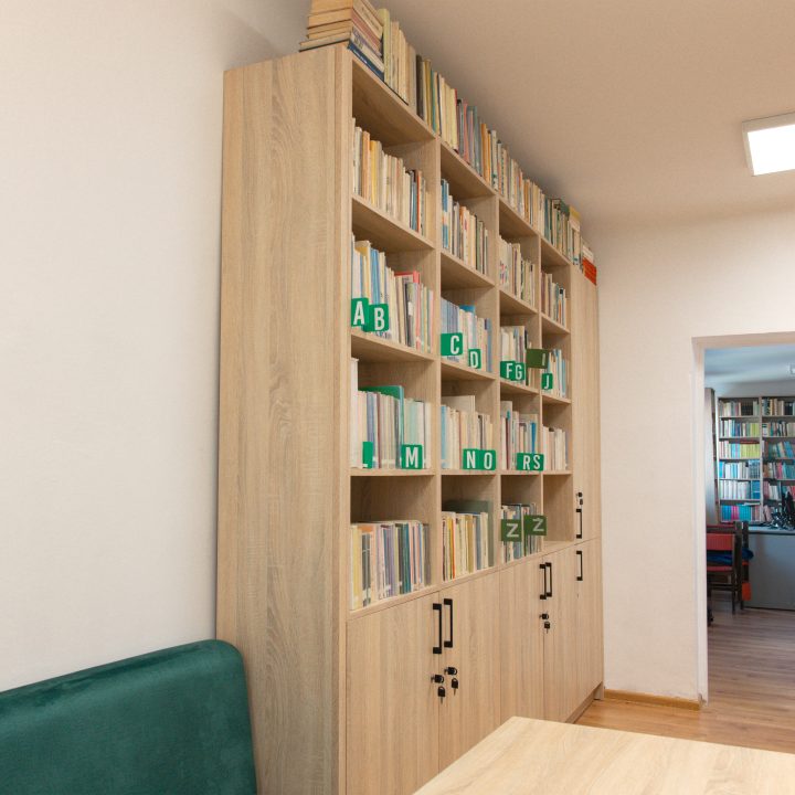 Realizacja MiD Business: meble na wymiar do szkoły w Dąbrowie. Biblioteka z regałami i siedziskami oraz gabinet dyrektora z szafą, biurkiem i komodą.