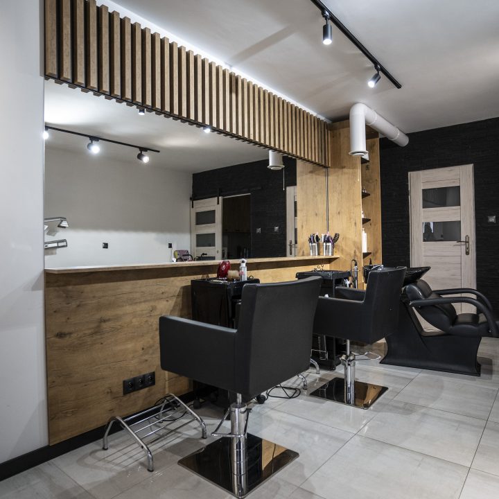 Meble na wymiar do salonu fryzjerskiego w Strzegowie – recepcja, biurko do manicure, ściana z lamelami i pomieszczenie socjalne. Realizacja MiD Business w 4 tygodnie.