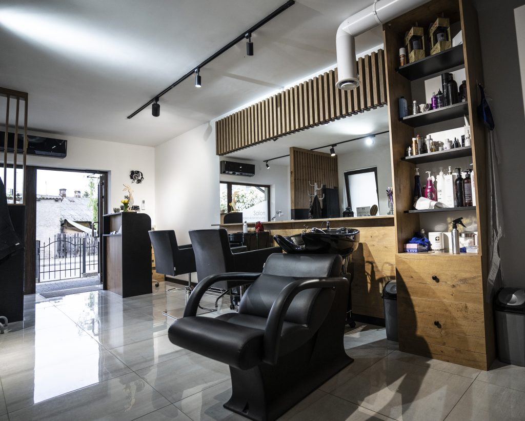 Meble na wymiar do salonu fryzjerskiego w Strzegowie – recepcja, biurko do manicure, ściana z lamelami i pomieszczenie socjalne. Realizacja MiD Business w 4 tygodnie.