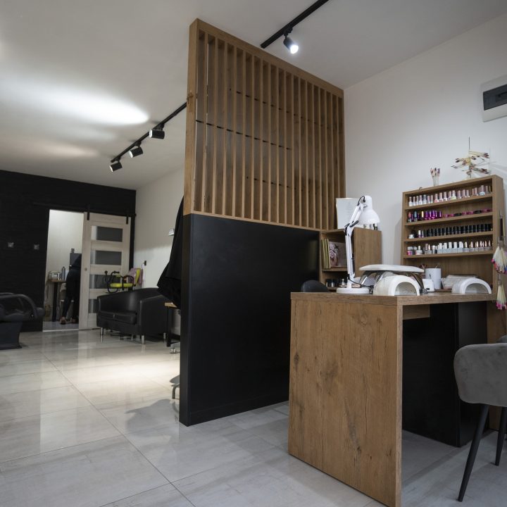 Meble na wymiar do salonu fryzjerskiego w Strzegowie – recepcja, biurko do manicure, ściana z lamelami i pomieszczenie socjalne. Realizacja MiD Business w 4 tygodnie.