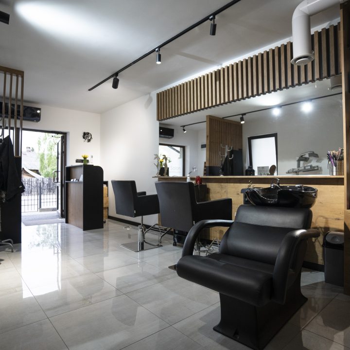 Meble na wymiar do salonu fryzjerskiego w Strzegowie – recepcja, biurko do manicure, ściana z lamelami i pomieszczenie socjalne. Realizacja MiD Business w 4 tygodnie.