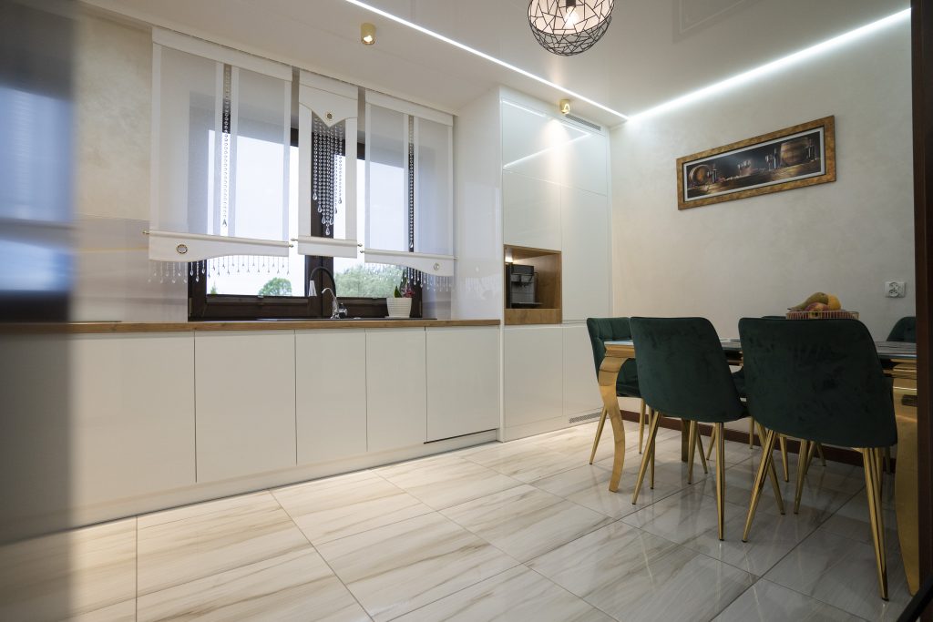 Kuchnia na wymiar w Strzegowie – białe fronty w połysku, dąb Lancelot i szkło z grafiką. Realizacja MiD Fast Fit w 5 tygodni – elegancja i funkcjonalność.