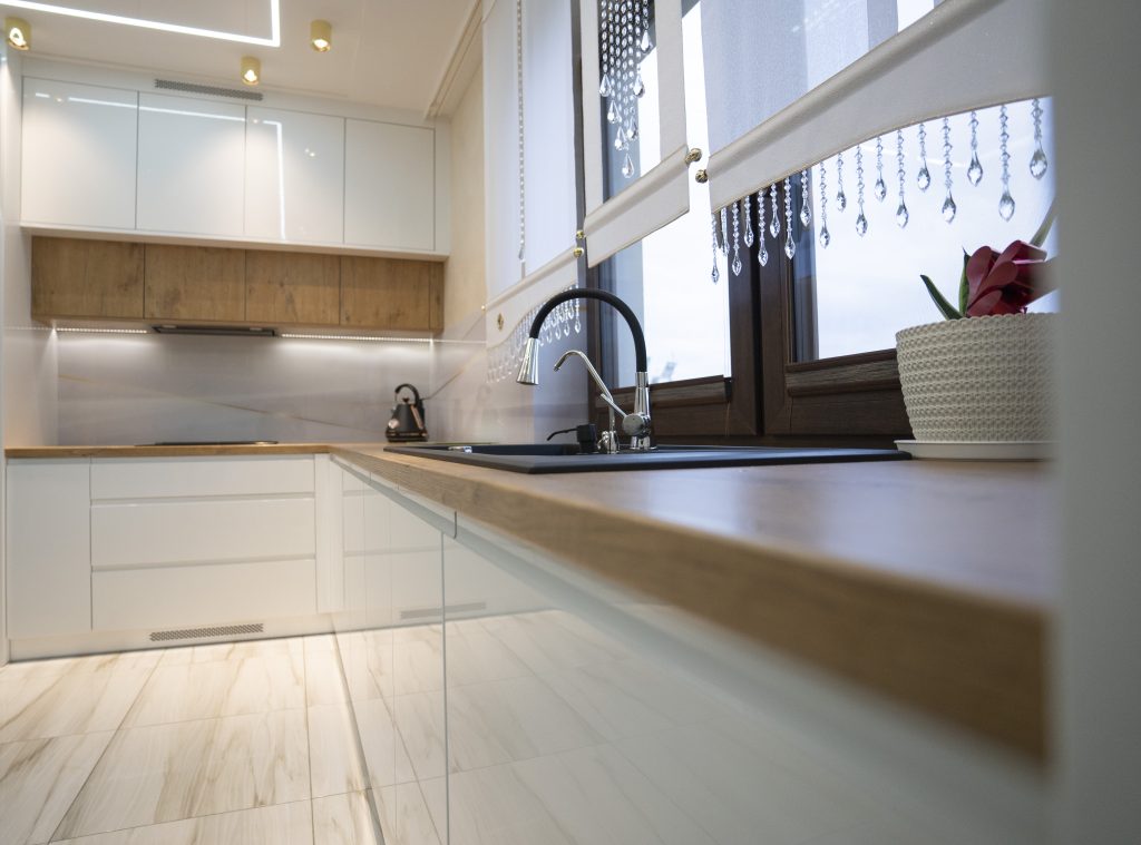 Kuchnia na wymiar w Strzegowie – białe fronty w połysku, dąb Lancelot i szkło z grafiką. Realizacja MiD Fast Fit w 5 tygodni – elegancja i funkcjonalność.