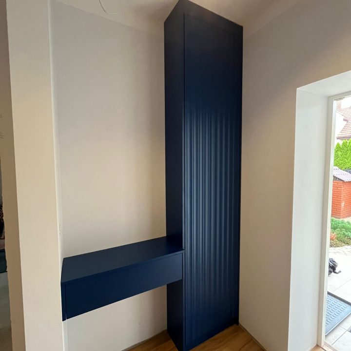 Szafa na wymiar w Warszawie – ryflowane fronty, asymetryczne uchwyty i głęboki odcień niebieskiego. Realizacja MiD Prestige: precyzja, funkcjonalność i charakter.