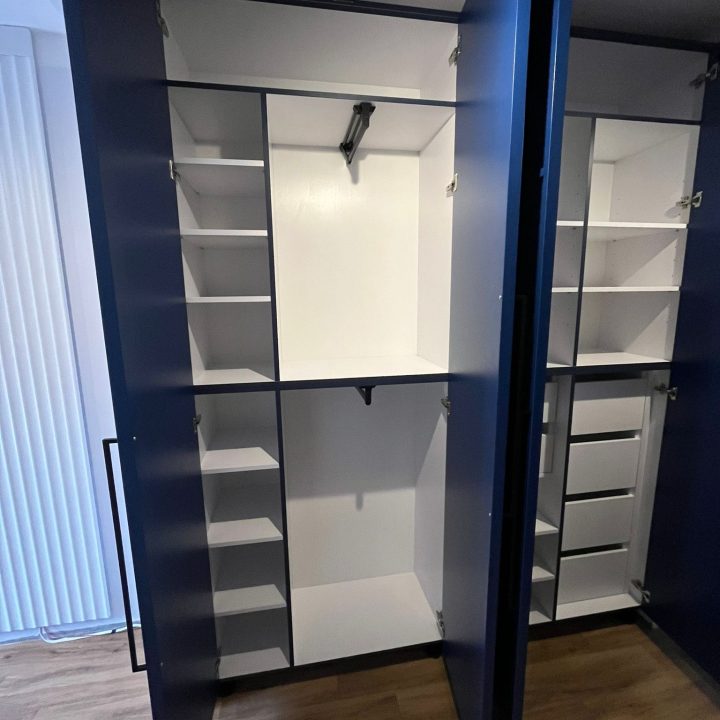 Szafa na wymiar w Warszawie – ryflowane fronty, asymetryczne uchwyty i głęboki odcień niebieskiego. Realizacja MiD Prestige: precyzja, funkcjonalność i charakter.