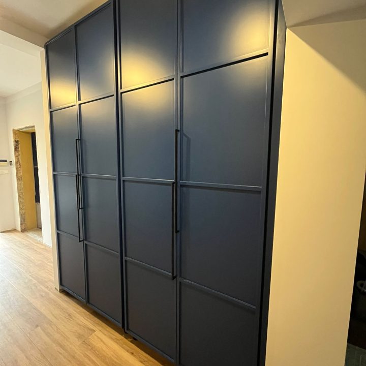 Szafa na wymiar w Warszawie – ryflowane fronty, asymetryczne uchwyty i głęboki odcień niebieskiego. Realizacja MiD Prestige: precyzja, funkcjonalność i charakter.