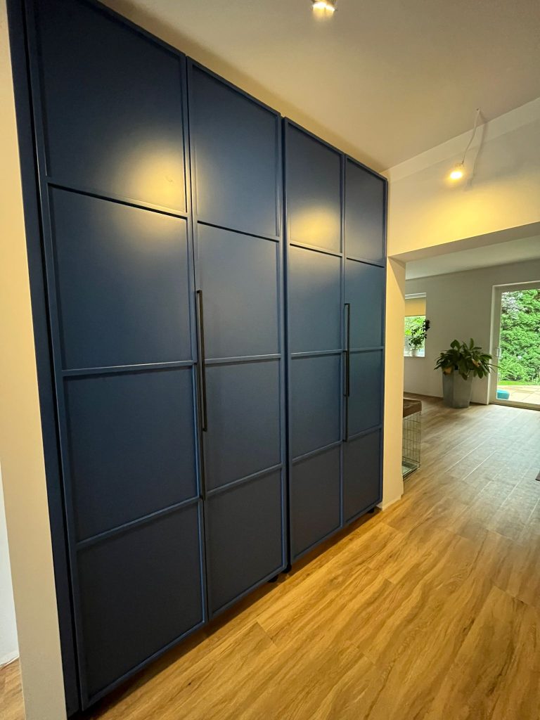 Szafa na wymiar w Warszawie – ryflowane fronty, asymetryczne uchwyty i głęboki odcień niebieskiego. Realizacja MiD Prestige: precyzja, funkcjonalność i charakter.