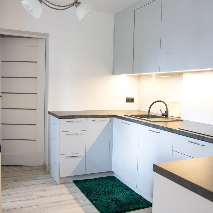 Nowoczesna kuchnia na wymiar w Słupsku – wyspa, wysoka zabudowa i szafki w dwóch głębokościach. Fronty akrylowe w szarym połysku i perfekcyjne dopasowanie. MiD Meble. MiD Faast Fit.