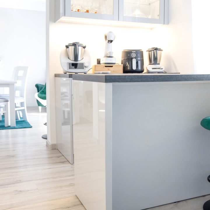 Nowoczesna kuchnia na wymiar w Słupsku – wyspa, wysoka zabudowa i szafki w dwóch głębokościach. Fronty akrylowe w szarym połysku i perfekcyjne dopasowanie. MiD Meble. MiD Faast Fit.