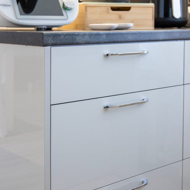 Nowoczesna kuchnia na wymiar w Słupsku – wyspa, wysoka zabudowa i szafki w dwóch głębokościach. Fronty akrylowe w szarym połysku i perfekcyjne dopasowanie. MiD Meble. MiD Faast Fit.