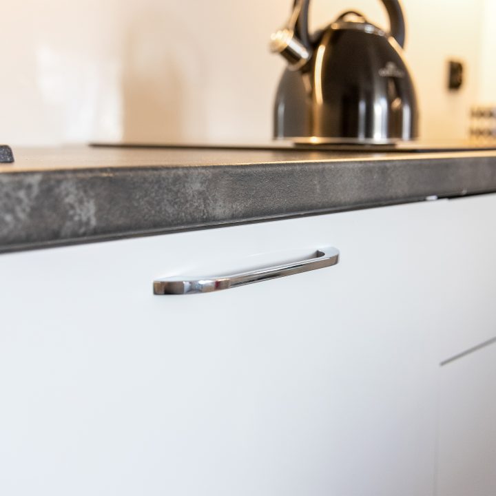 Nowoczesna kuchnia na wymiar w Słupsku – wyspa, wysoka zabudowa i szafki w dwóch głębokościach. Fronty akrylowe w szarym połysku i perfekcyjne dopasowanie. MiD Meble. MiD Faast Fit.