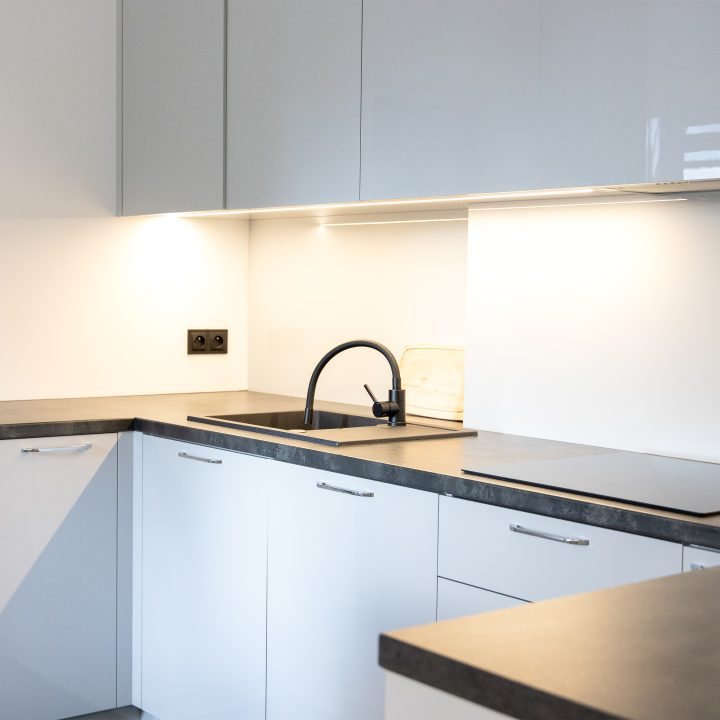 Nowoczesna kuchnia na wymiar w Słupsku – wyspa, wysoka zabudowa i szafki w dwóch głębokościach. Fronty akrylowe w szarym połysku i perfekcyjne dopasowanie. MiD Meble. MiD Faast Fit.