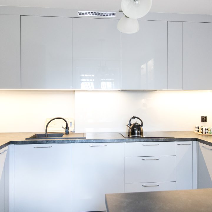 Nowoczesna kuchnia na wymiar w Słupsku – wyspa, wysoka zabudowa i szafki w dwóch głębokościach. Fronty akrylowe w szarym połysku i perfekcyjne dopasowanie. MiD Meble. MiD Faast Fit.