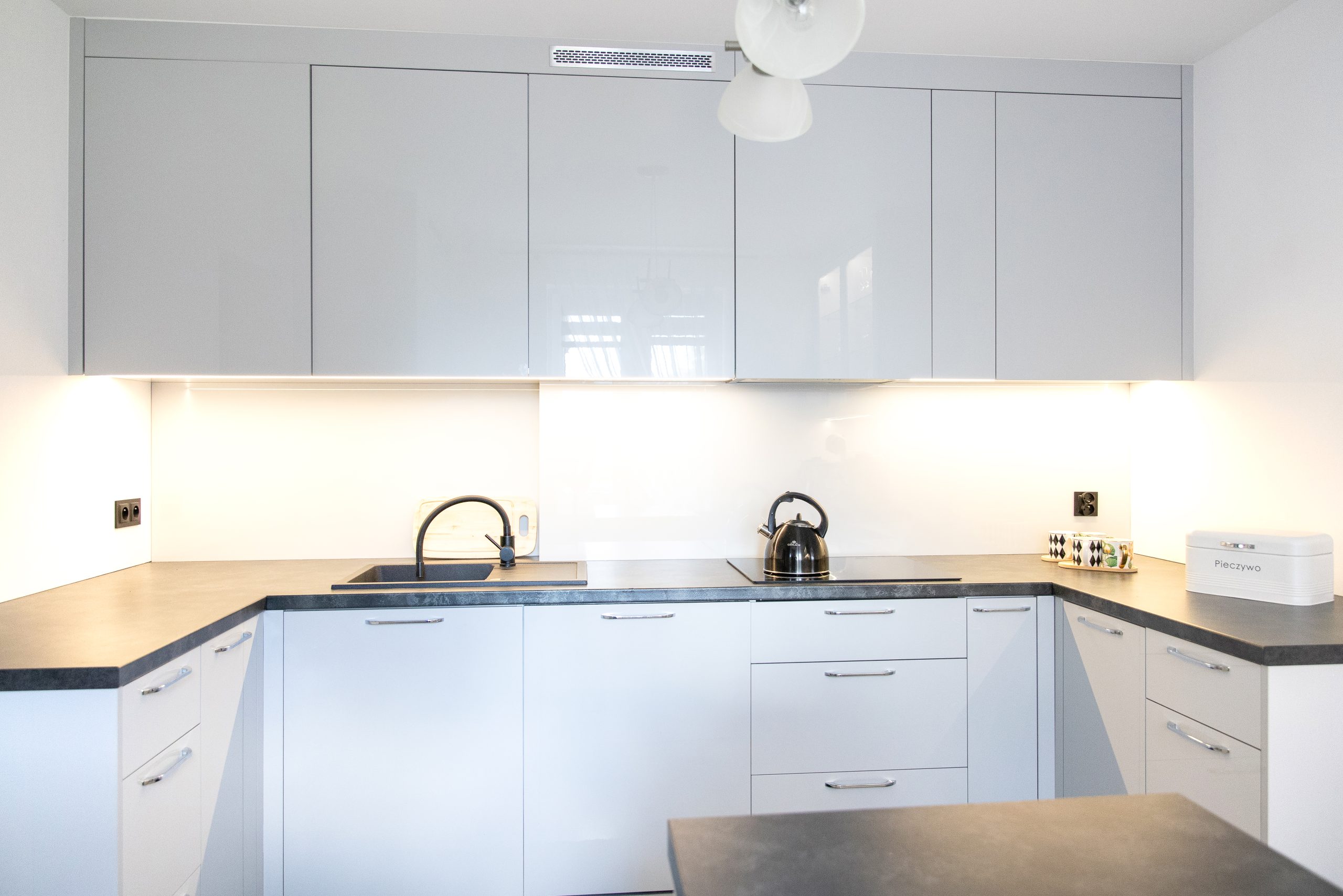 Nowoczesna kuchnia na wymiar w Słupsku – wyspa, wysoka zabudowa i szafki w dwóch głębokościach. Fronty akrylowe w szarym połysku i perfekcyjne dopasowanie. MiD Meble. MiD Faast Fit.