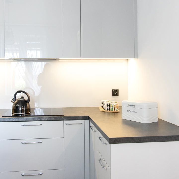 Nowoczesna kuchnia na wymiar w Słupsku – wyspa, wysoka zabudowa i szafki w dwóch głębokościach. Fronty akrylowe w szarym połysku i perfekcyjne dopasowanie. MiD Meble. MiD Faast Fit.