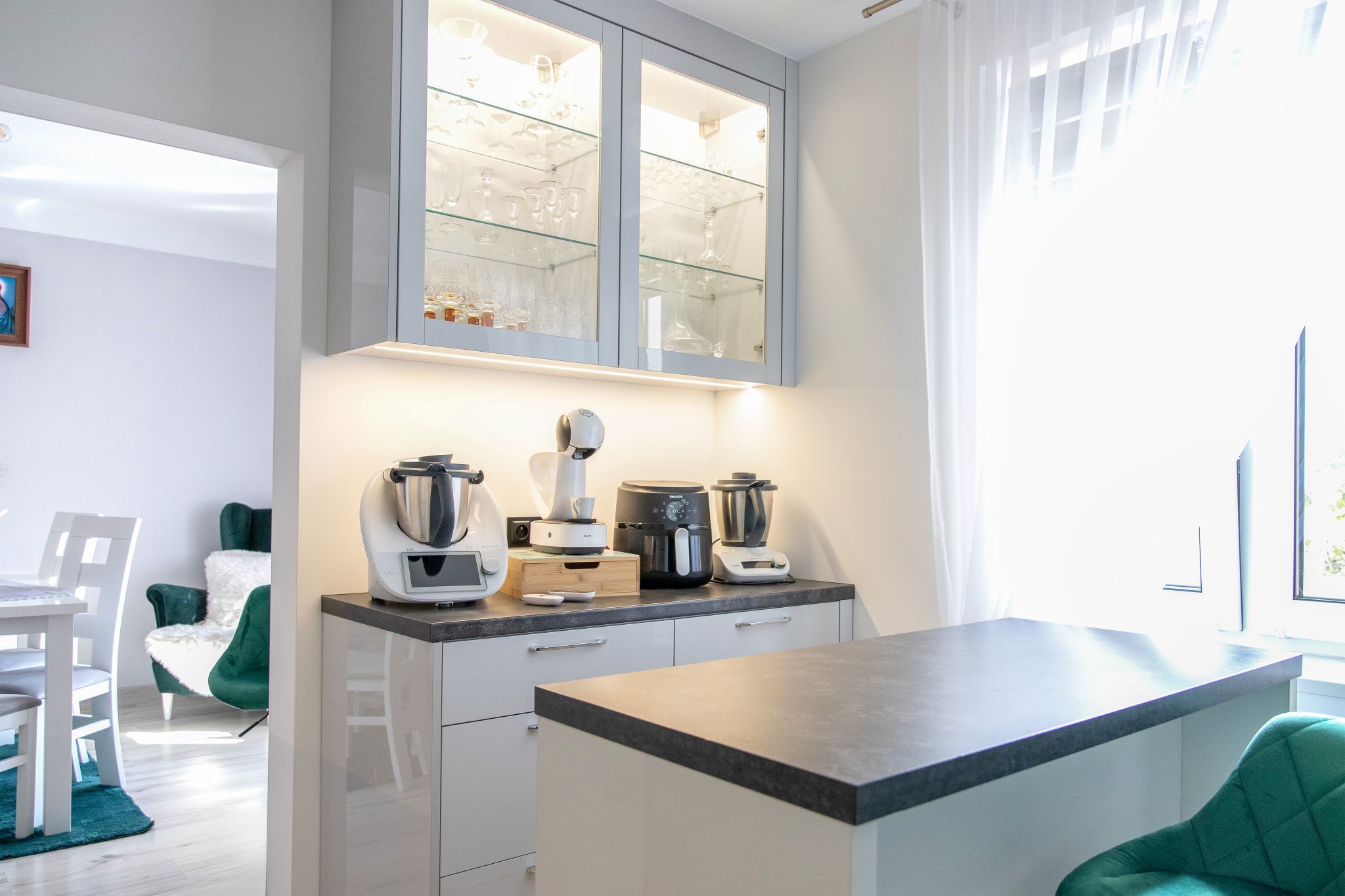 Nowoczesna kuchnia na wymiar w Słupsku – wyspa, wysoka zabudowa i szafki w dwóch głębokościach. Fronty akrylowe w szarym połysku i perfekcyjne dopasowanie. MiD Meble. MiD Faast Fit.