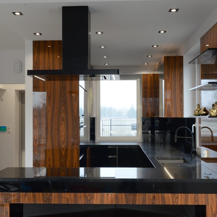 Kuchnia na wymiar w Łomiankach – czarny połysk, fornir palisandrowy i blat z kamienia. Elegancja, jakość i styl w pakiecie MiD Prestige.