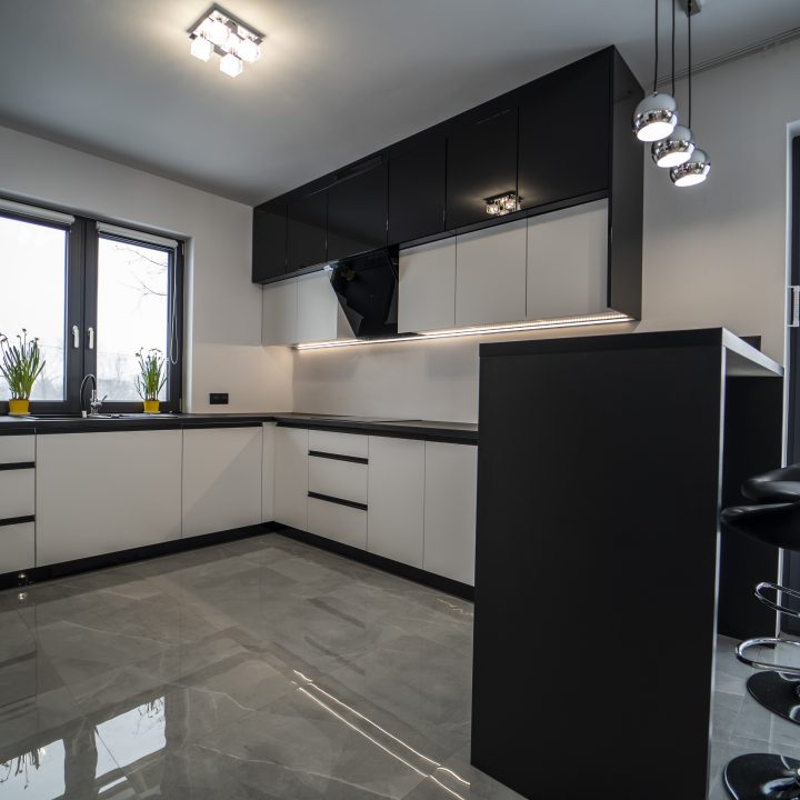 Nowoczesna kuchnia na wymiar w Pułtusku – biel i czerń w połysku, wyspa, oświetlenie LED i szafa we wiatrołapie. Styl, ergonomia i trwałość w pakiecie MiD Smart.