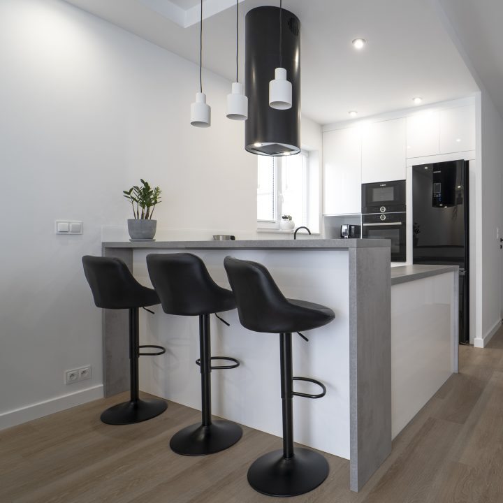 Kuchnia na wymiar Ożarów Mazowiecki – białe fronty w połysku, betonowy blat i wyspa dwupoziomowa. Styl, ergonomia i jakość w pakiecie MiD Smart.